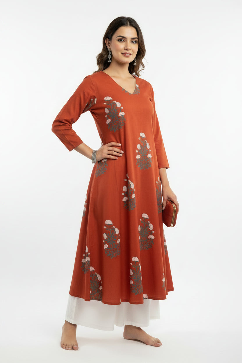 An orange-red long-sleeve kurta with gray and white floral patterns, displayed on a black mannequin torso in an indoor setting.